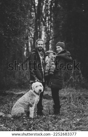 New born family photo shoot in the fall by the woods in black and white