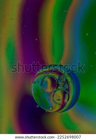 Oil drops in water and air bubbles, macro photo, selective focus. Acid colors background. Vertical photo 