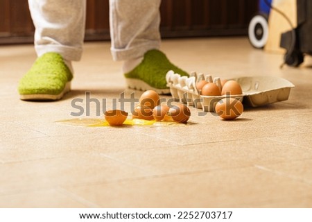 Accidental egg breakage on kitchen floor Royalty-Free Stock Photo #2252703717
