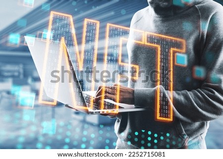 Close up of hacker hand using laptop with glowing nft hologram on blurry pixel interior background. Non fungible token and cryptocurrency concept. Double exposure