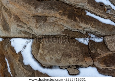 Photo of a stone rock with snow lying on it. natural textures