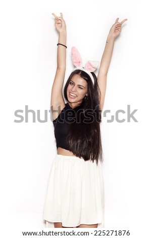 Young teenage girl in pink bunny ears. Sweet woman having fun on white background, not isolated