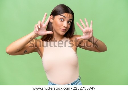 Young caucasian woman isolated on green chroma background counting eight with fingers