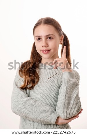Cute kid raised her index finger while answering the question. Girl 10 years old, caucasian, blonde. Concept of study, idea, excellent student, find the answer. Schoolgirl. Royalty-Free Stock Photo #2252742675