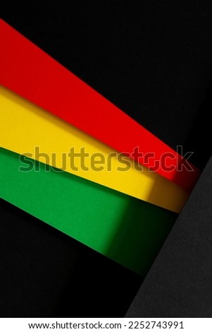 Black History Month color background. African American history month celebration. Abstract red, yellow, green color flag on black paper background Royalty-Free Stock Photo #2252743991
