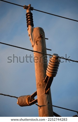 Utility poll with power lines and a blue sky backdrop. 
