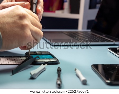 A technician repairs a smartphone in a laboratory with copy space. concept of computer hardware, mobile phones, electronics, repair, upgrade and technology. Close-up.