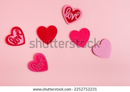 Horizontal card with pink and red colored love hearts from above on light pink background. Romantic picture for Valentine's Day.
