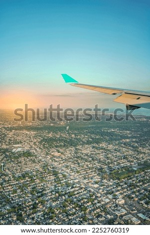 Aerial view from airplane window of wing flying over city during a flight. Colorful landscape view