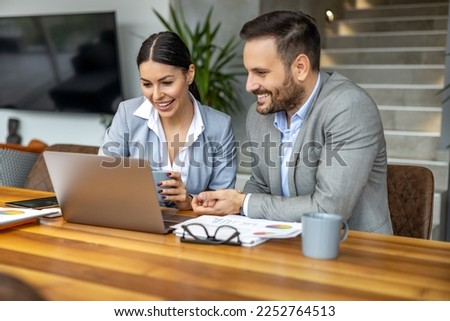 Two business people using laptop and discussing about new project at office,preparing presentation and having brainstorming session. Royalty-Free Stock Photo #2252764513