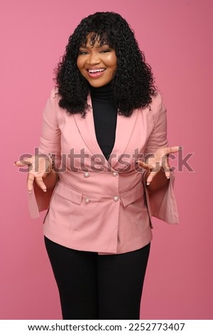 Young African Woman wearing pink business suit asking question in good faith with arms and hands raised. doubt concept.Looking at camera, shrugging hands towards the body Royalty-Free Stock Photo #2252773407