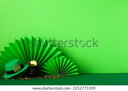 Happy St Patrick's Day concept. Banner template with abstract paper fans, leprechaun's hat, pot of gold coins on green background.
