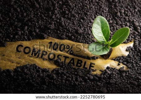 Biodegradable and Compostable Plastic Concept. Renewable Raw Materials. Used plastic is under the Planting Soil and a Seed can Grow Well  Royalty-Free Stock Photo #2252780695