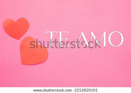 Image of two red hearts cut out on a pink background with the phrase I love you, ideal for romantic moments and Valentine's Day