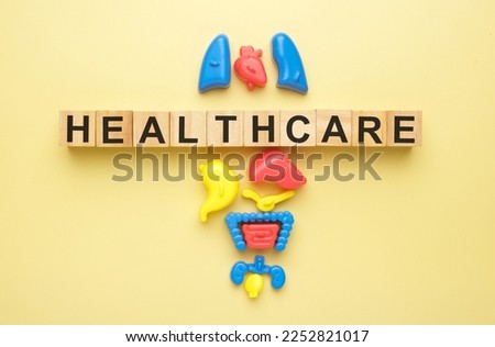 Flatlay picture of toy organ with the wooden block written healthcare.