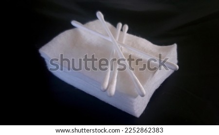 close up photo of cotton and cotton buds on black background