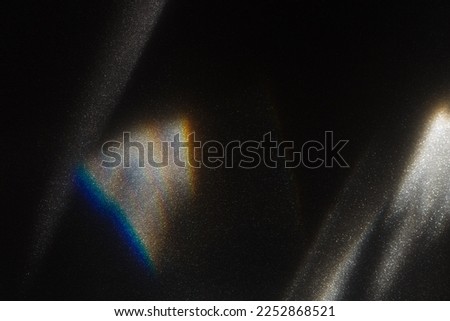 Rainbow light effect from sun flares on black background, colorful glare and shine, light rays on sparkling surface. Rainbow refraction of sunlight. Natural light effects, iridescent colors Royalty-Free Stock Photo #2252868521