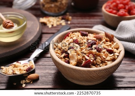 Tasty granola served with nuts and dry fruits on wooden table