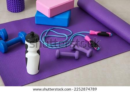 Sports water bottle with equipment on mat in gym