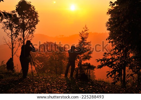 silhouette of photographers taking photos during sunrise
