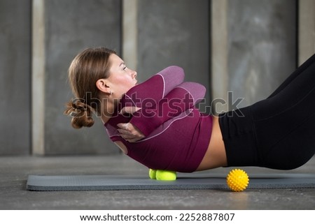 A woman massages the trigger point of her back with balls. The concept of myofascial release, self-massage. Royalty-Free Stock Photo #2252887807