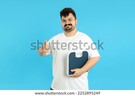 Concept of weight loss, young fat man on blue background