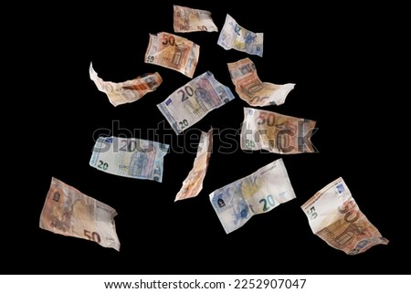 Flying money, twenty and fifty paper banknotes in euro currency coming down, isolated on a back background, finance concept, business success, investment or lottery win, copy space, selected focus