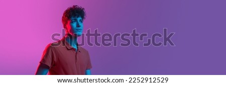 Horizontal banner with portrait of young man over background in neon light. Beauty, fashion, youth concept. Copy space for ad, text