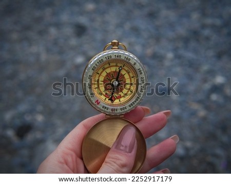 close up of golden compass in hand,streetb background .