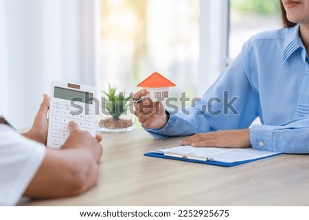 Real estate concept. House model with real estate agent and customer discussing for contract to buy house, insurance or loan real estate.