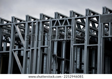 Building construction from metal trusses. lattice structure of the frame of an industrial building. A large thick tangle on the ceiling of a building under construction. shiny metal profiles steel Royalty-Free Stock Photo #2252946081