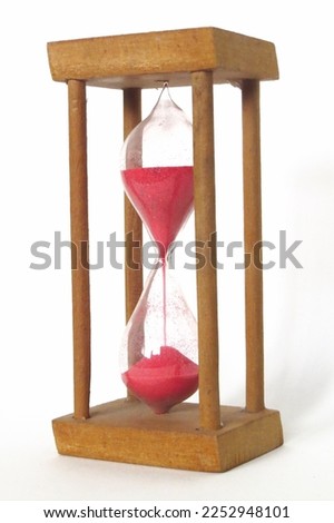 Hourglass containing magenta sand, supported by wood columns and isolated by white background 