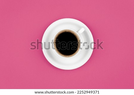 Cup of coffee and saucer on a pink background, flat lay.