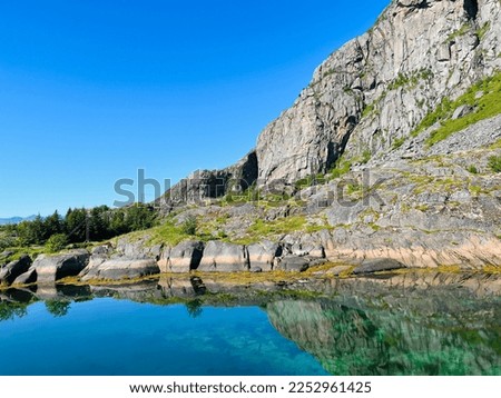 Beautiful rocky mountain reflection at the sea water surface