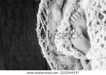Closeup picture of newborn baby feet on knitted plaid