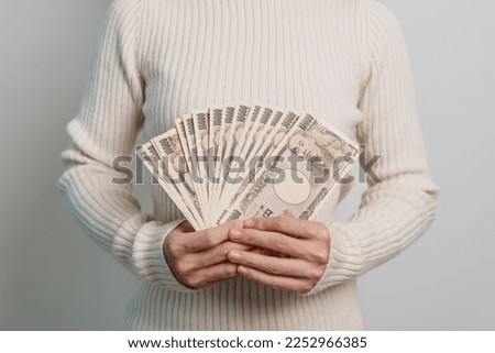 Woman hand holding Japanese Yen banknote stack. Thousand Yen money. Japan cash, Tax, Recession Economy, Inflation, Investment, finance and shopping payment concepts Royalty-Free Stock Photo #2252966385
