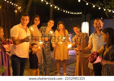 Group of wedding guests holding burning Bengal lights outdoors at wedding cocktail party. Happiness, joy and celebration concept Royalty-Free Stock Photo #2252981325