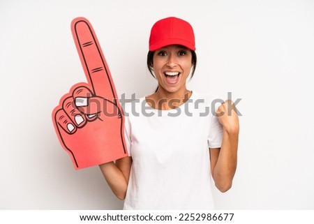 hispanic pretty woman feeling shocked,laughing and celebrating success. number one hand fan concept Royalty-Free Stock Photo #2252986677