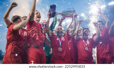 Football Finals Tournament Winning Team Celebrates Victory Cheering and Lifting Trophy Prize on Stadium. Happy Soccer Players Champions of International Championship Cup. Fireworks Shot. Royalty-Free Stock Photo #2252995833