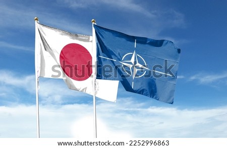 Japan flag and Atlantic Treaty Organization flag on cloudy sky. waving in the sky