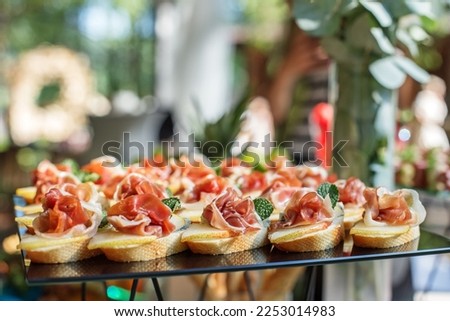 catering buffet table with snacks and appetizers. Set of canapés with jamon, bruschetta, pear and cheese and mint Royalty-Free Stock Photo #2253014983