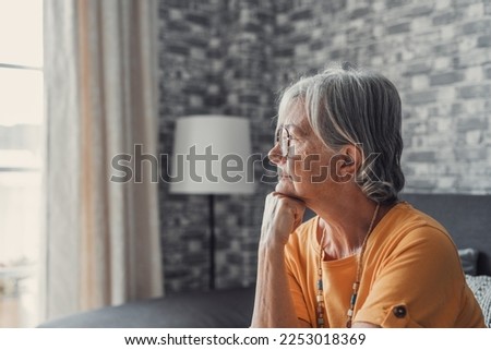 Face of senior caucasian hoary woman looking away deep in sad thoughts feels lonely close up portrait, recollect memories and life moments, depressed grandmother alone indoors, yearning for husband  Royalty-Free Stock Photo #2253018369