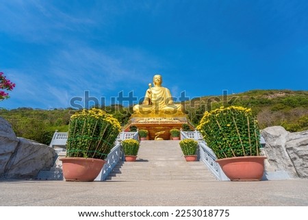 Ariel view Golden Buddha statue's hand holding lotus at Chon Khong Monastery which attracts tourists to visit spiritually on weekends in Vung Tau, Vietnam. Travel concept.