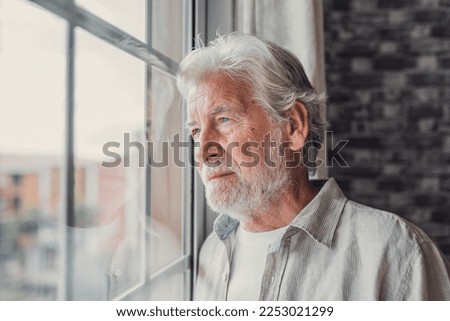 Pensive elderly mature senior man in eyeglasses looking in distance out of window, thinking of personal problems. Lost in thoughts elderly middle aged grandfather suffering from loneliness, copy space Royalty-Free Stock Photo #2253021299