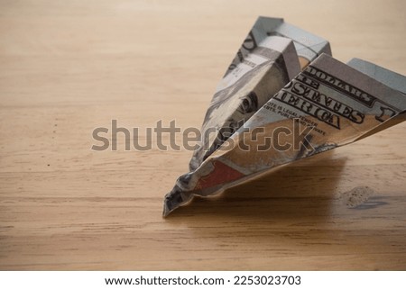 US dollar banknote plane crash on wooden table background copy space. Hard landing economy, recession economic, global world economic crisis due to inflation or FED control interest rates concept. Royalty-Free Stock Photo #2253023703