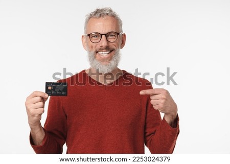 Smiling caucasian mature middle-aged bank employee man client customer pointing at credit card with cashback cashless transactions payment e-banking loan debt isolated in white background