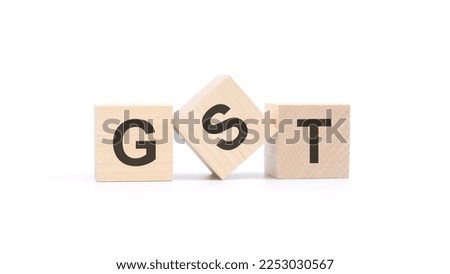 word GST made with wood building blocks, white background.