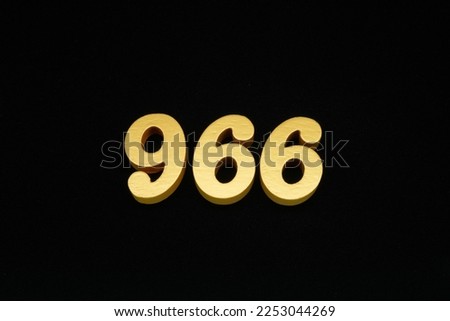 Numbers in golden yellow on a black background, numbers made of wood, then painted in yellow gold, placed on a black cloth background.