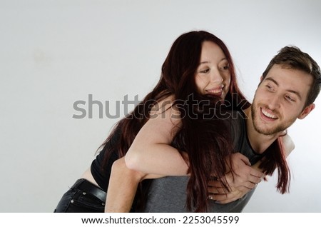 Young couple in love. The man carries his girlfriend on his back. Concept of love and valentine's day. White and isolated background