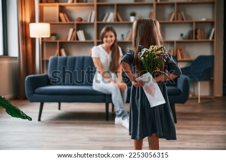Happy mother's day. Giving a gift. Young woman with her daughter is together at apartment.